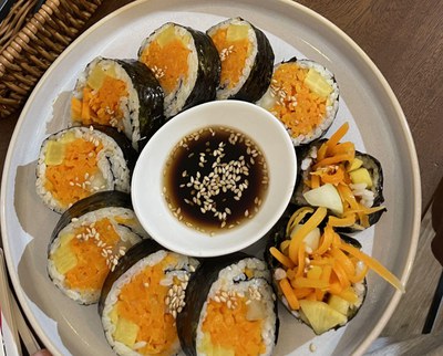 Imatge d'un plat de kimbap amb un bol de soja i sèsam al centre. Imatge sota llicència CC0 de Tilak Bahadur Karki, extreta de "WordPress Photo Directory": https://wordpress.org/photos/photo/5526a0c31e/.