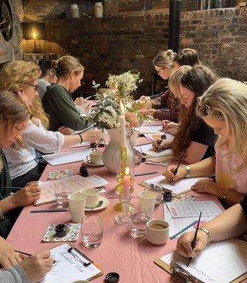 Un grup de dones escrivint al voltant d’una taula.