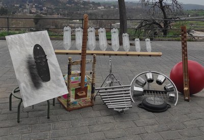 Conjunt d'instruments reciclats com ara ampolles de plàstic en vertical disposades en renglera.