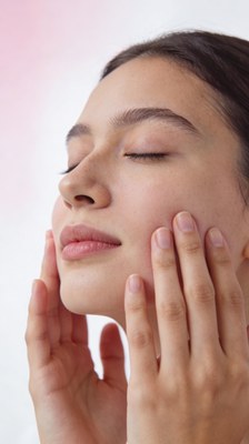 Noia que es fa un automassatge facial.